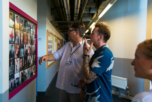 (left to right) Stuart Worden, Danny Jones & Alex Cruickshank looking at a wall of The BRIT School’s famous alumni.